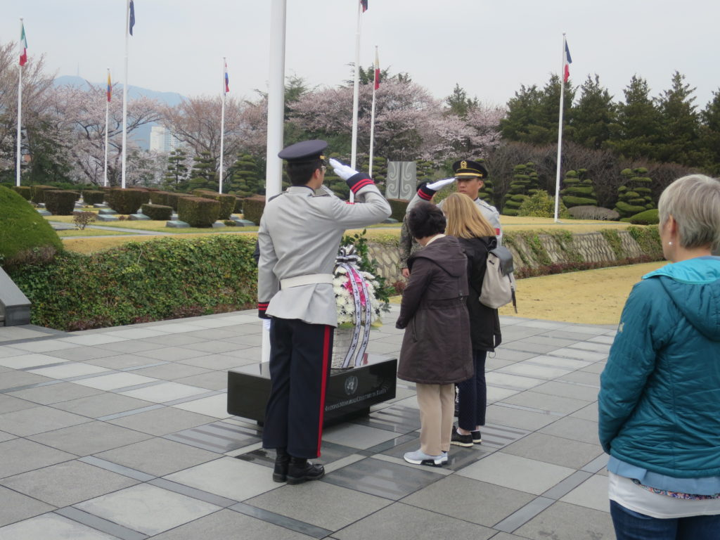 At the daily flag-lowering ceremony, the soldiers salute as the family members of one of the interred pay their respects.